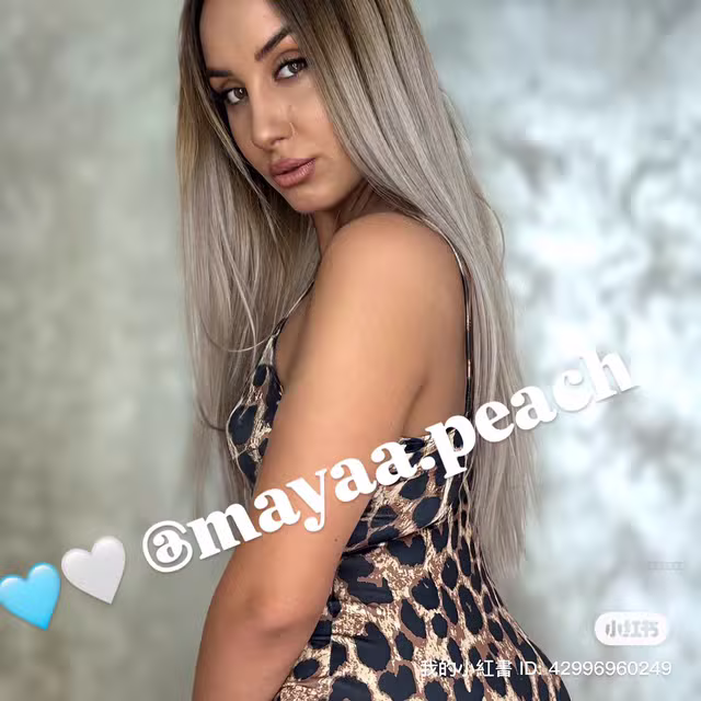 mayaa.peach turns with elegance in a leopard print dress, her hair flowing softly.